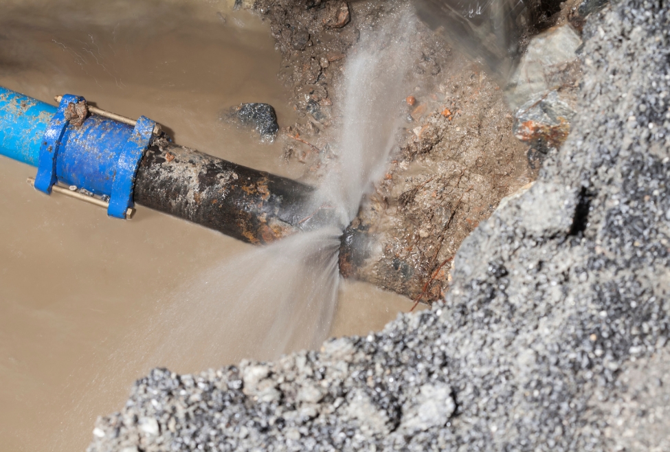 Plumbing and leak detection technician inspecting a pressurized line