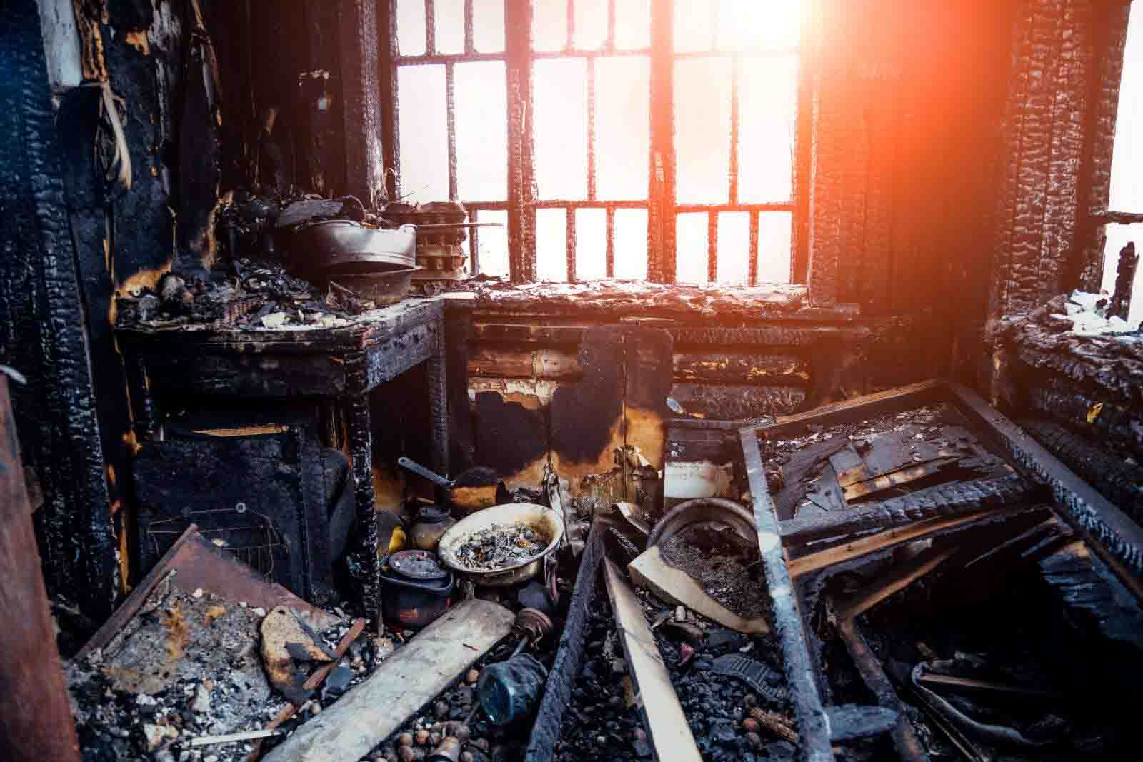Restoration professional cleaning soot from walls in a fire-damaged US home
