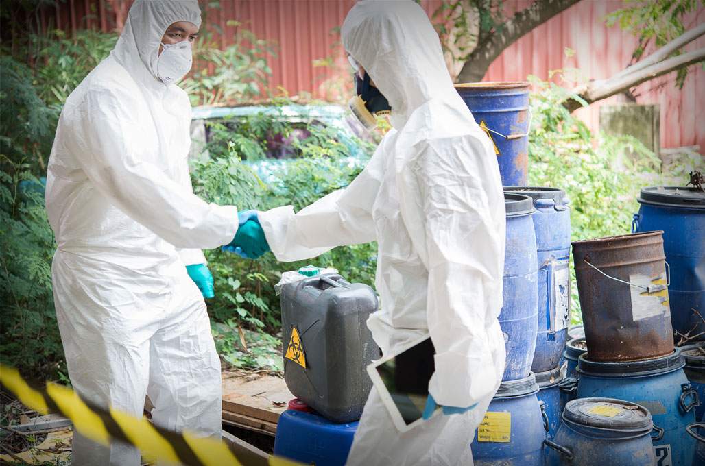 Restoration worker in protective gear handling sewage cleanup in a US property