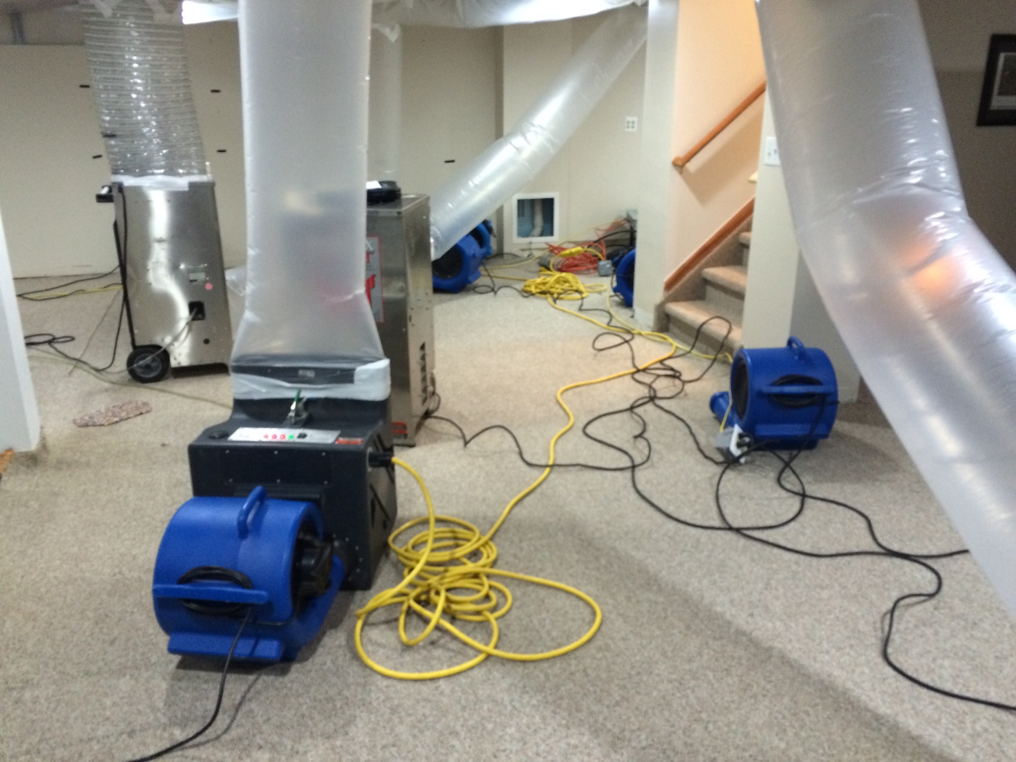 Restoration crew with industrial drying equipment in a water-damaged home